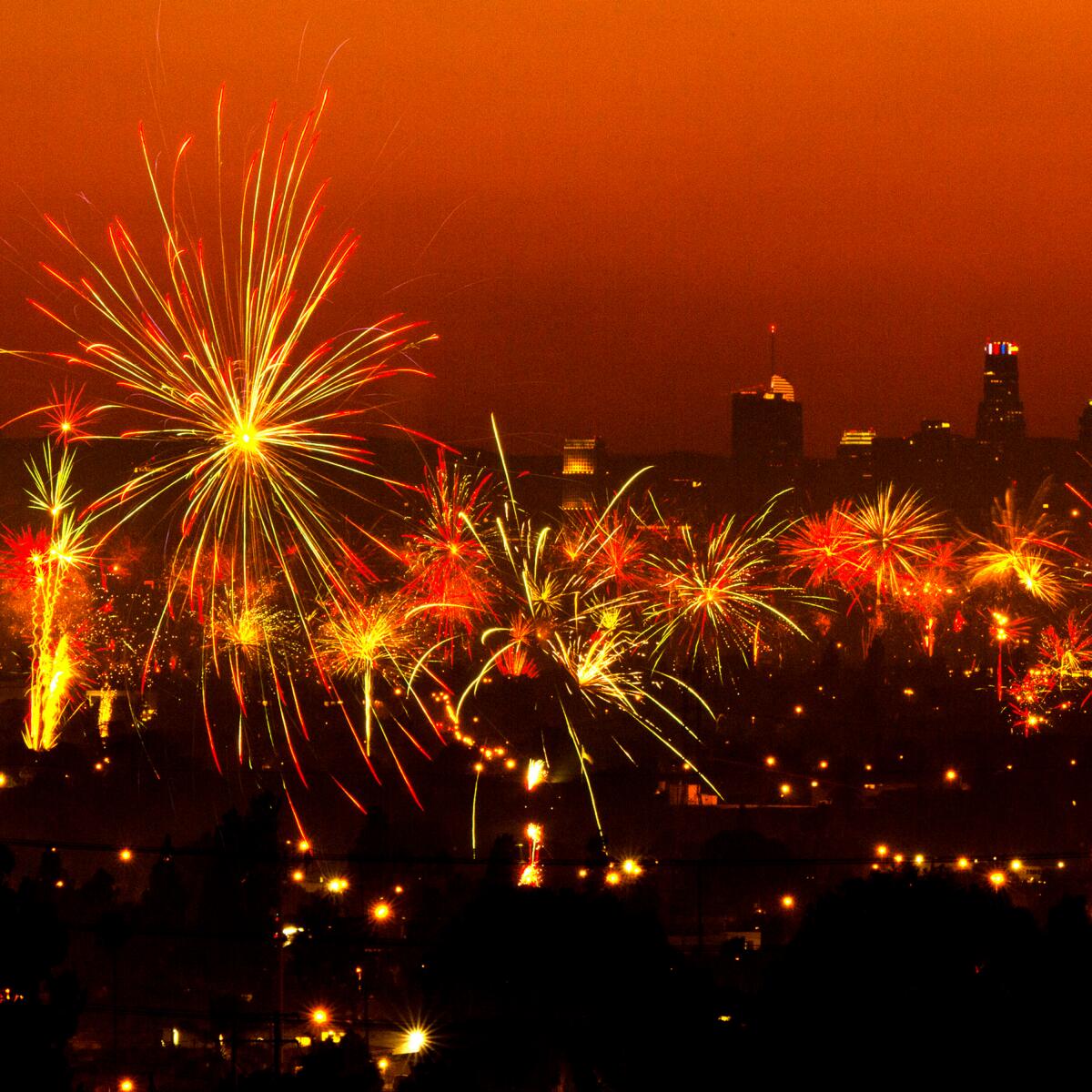 A dark Los Angeles skyline can be seen behind the exploding fireworks.