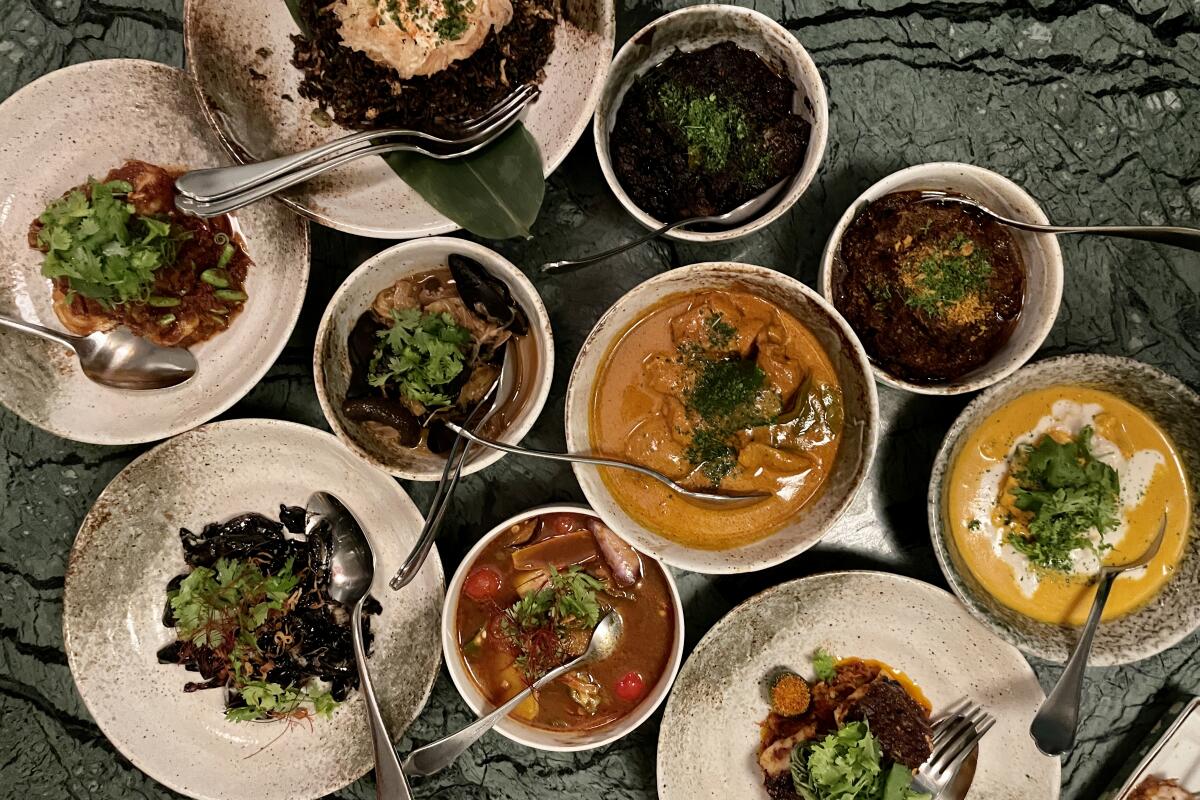 An array of Peranakan dishes from Malcolm Lee's Candlenut restaurant in Singapore including curries and stir-fries.