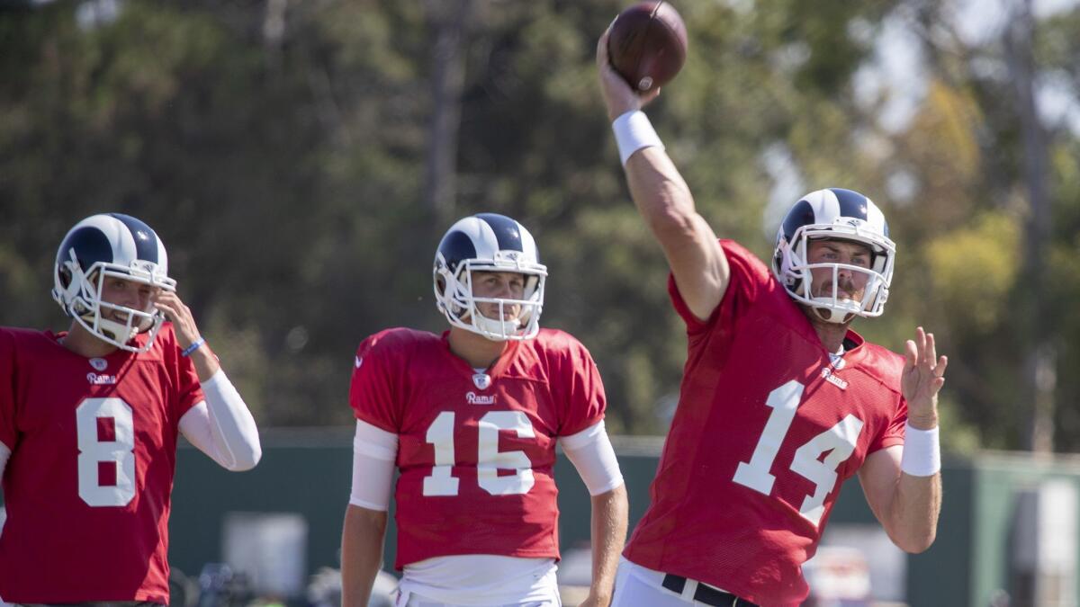 Rams quarterbacks Brandon Allen, left, and Jared Goff, center, watch Sean Mannion make a pass at the Los Angeles Rams training camp at UC-Irvine.