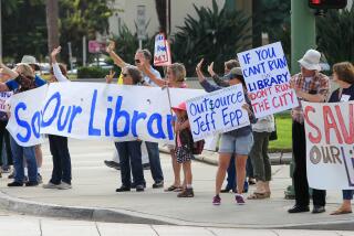 SAN DIEGO, CA August 23rd, 2017 | People opposing the plan to outsource library services hold up signs and wave to traffic outside Escondido City Hall before a council meeting on Wednesday in Escondido, California. | (Eduardo Contreras / San Diego Union-Tribune)