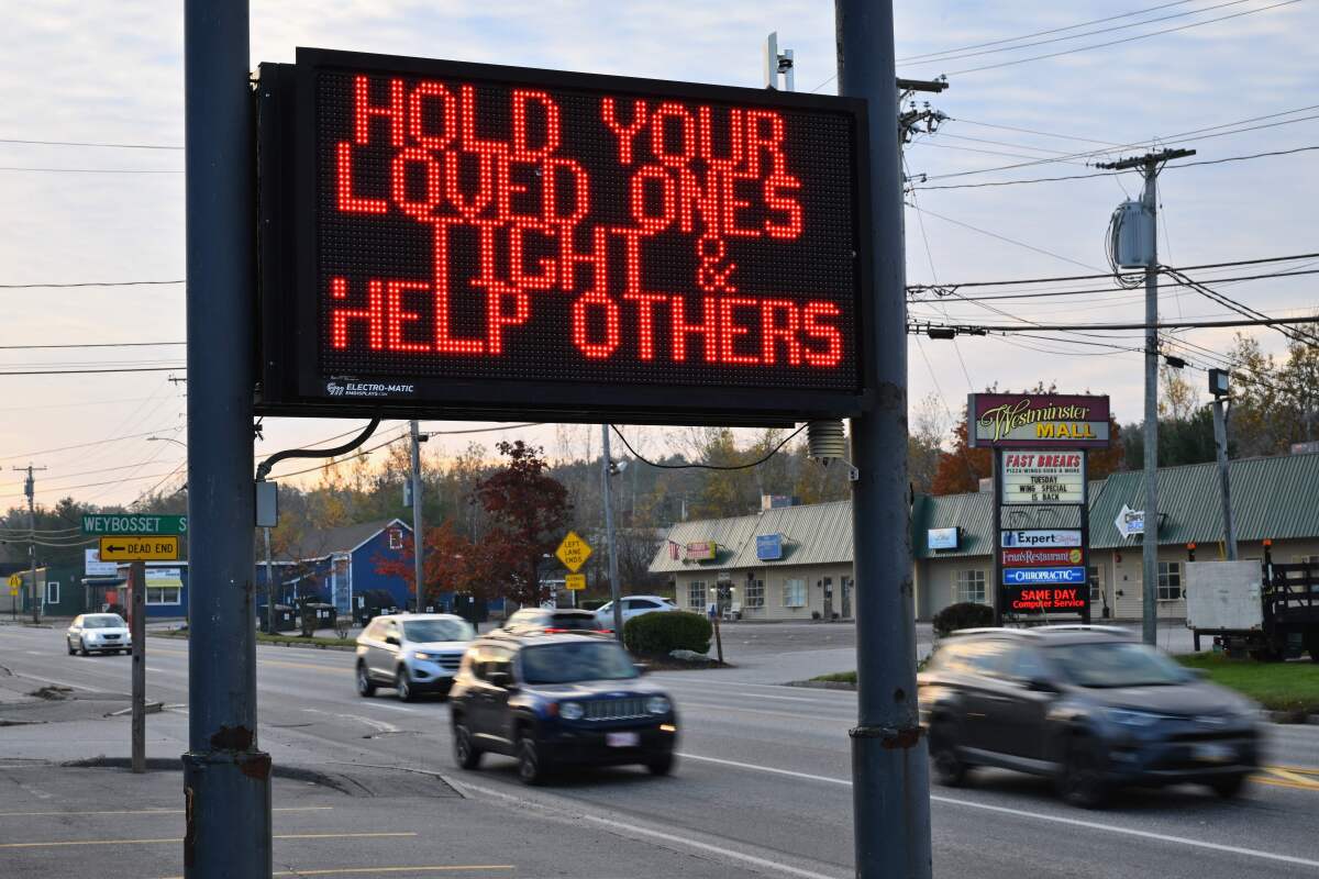 A roadside sign reads: Hold your loved ones tight & help others
