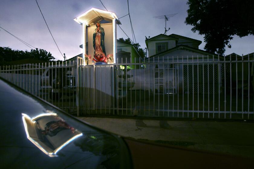 A sidewalk shrine glows in front of Guadalupe "Lupita" Villalobos' house in Compton, Calif. The psychic offered guidance on drug shipments to Gabriel Dieblas Roman, a Sinaloa cartel cocaine smuggler who sometimes left her a $2,000 tip for a $20 reading.