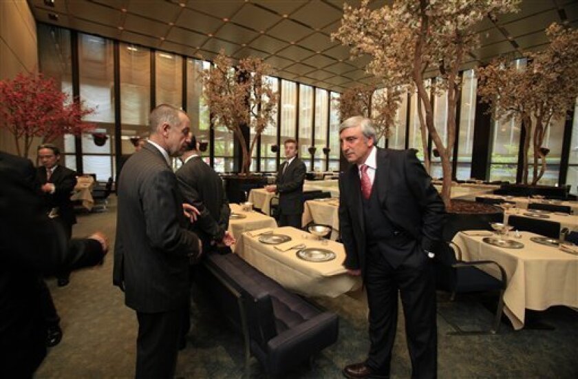 Julian Niccolini, right, managing partner of the Four Seasons restaurant, straightens a table cloth as he prepares the Pool Room for lunch, in New York, Friday, May 1, 2009. (AP Photo/Richard Drew)