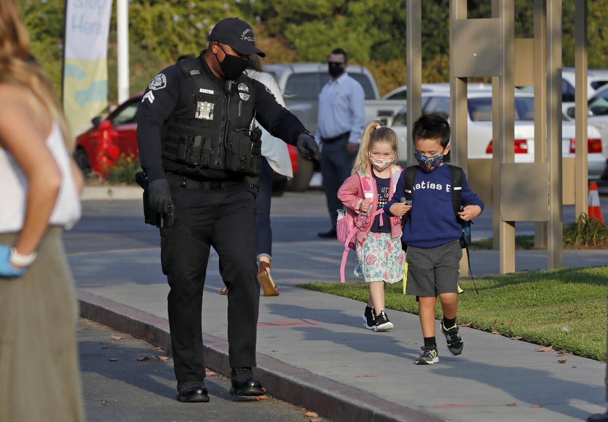 School Resource Officer Cornelius Ashton directs a couple of students to their class at Top of the World Elementary School.