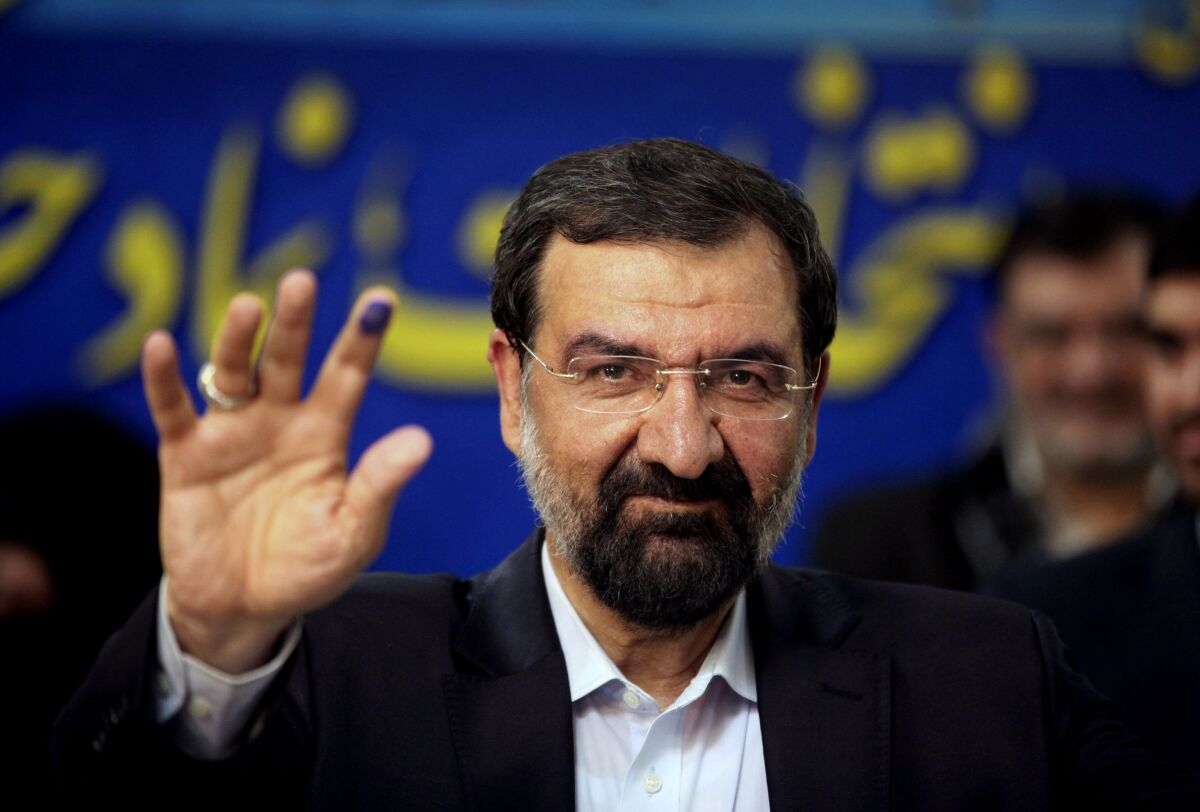 FILE - Mohsen Rezaei waves to reporters after registering as a presidential candidate, in Tehran, Iran, May 10, 2013. Argentina’s Foreign Ministry said Tuesday, Jan. 11, 2022, that the appearance of Rezaei, at the investiture of Nicaragua’s president on Monday was “an affront to Argentine justice and to the victims of the brutal terrorist attack″. Rezaei, a former leader of Iran’s paramilitary Revolutionary Guard, is wanted by Argentina on an Interpol “Red Notice” alleging he was involved in the 1994 bombing of a Jewish center in Buenos Aires that killed 85 people. (AP Photo/Vahid Salemi, File)