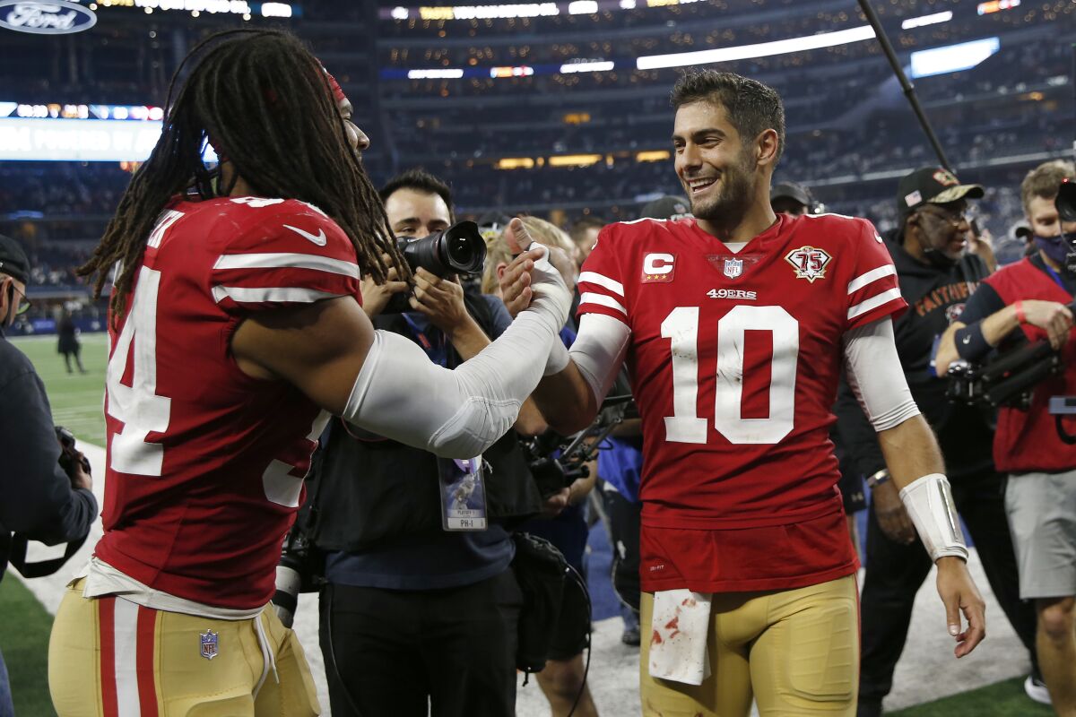 San Francisco 49ers middle linebacker Fred Warner, left, celebrates with quarterback Jimmy Garoppolo (10) after the 49ers defeated the Dallas Cowboys in an NFL wild-card playoff football game in Arlington, Texas, Sunday, Jan. 16, 2022. (AP Photo/Roger Steinman)