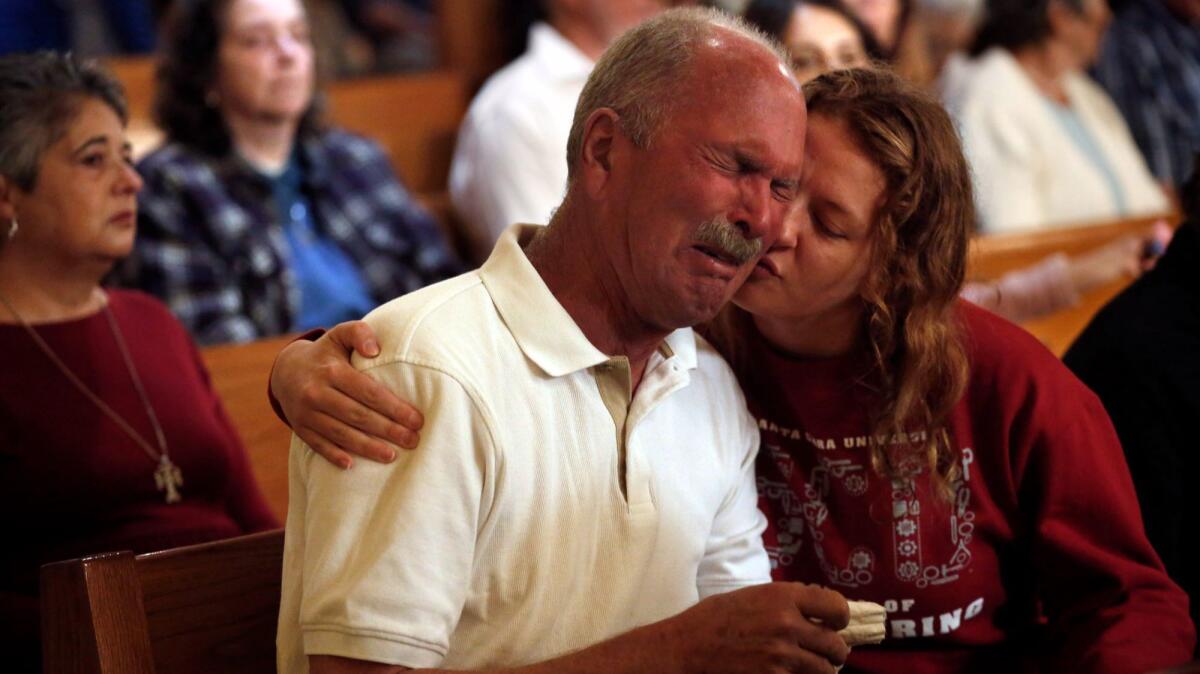 Jim Schettler cries during Mass at St. Rose Catholic Church in Santa Rosa. His daughter and her family lost their home in Fountaingrove and have moved in with Schettler and his wife.
