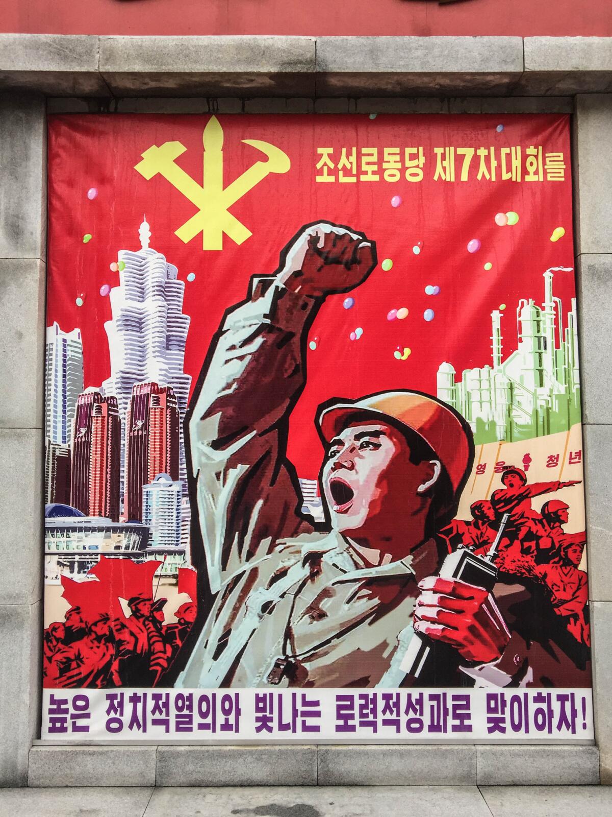 A piece of propaganda art outside the factory. The poster exhorts workers to work hard ahead of the party congress. Depicted in the background are skyscrapers from the new “Future Science Street” in Pyongyang, a residential district for scientists and professors that was built at the behest of Kim Jong Un. It reads: "Let us greet the 7th Workers Party Congress with a high sense of political enthusiasm and brilliant labor achievements." (Julie Makinen / Los Angeles Times)