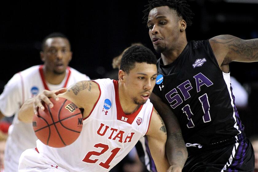 Utah forward Jordan Loveridge drives on Stephen F. Austin forward Clide Geffrard in the second half of the Utes' 57-50 victory on Thursday night.