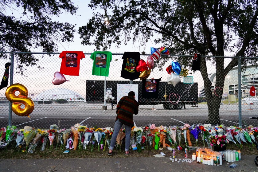 HOUSTON, TX - NOVEMBER 07: A visitor writes a note at a memorial outside of the canceled Astroworld festival at NRG Park on November 7, 2021 in Houston, Texas. According to authorities, eight people died and 17 people were transported to local hospitals after what was described as a crowd surge at the Astroworld festival, a music festival started by Houston-native rapper and musician Travis Scott in 2018. (Photo by Alex Bierens de Haan/Getty Images)