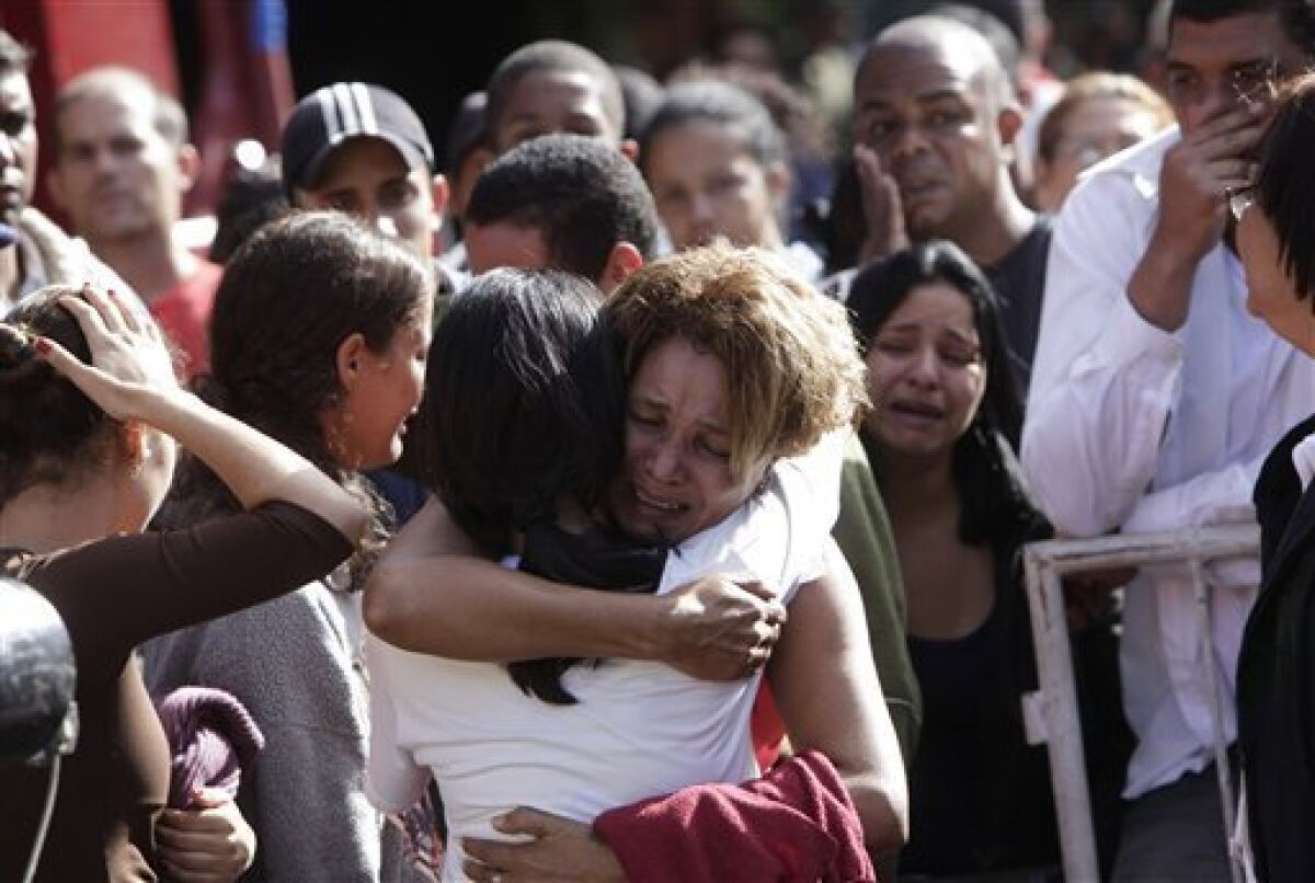 Relatives mourn the deaths of landslide victims in the Morro do Bumba area of the Niteroi neighborhood in Rio de Janeiro, Thursday, April 8, 2010. At least 200 people were buried and feared dead under the latest landslide to hit a slum in Rio de Janeiro's metropolitan area, authorities said Thursday. (AP Photo/Felipe Dana)