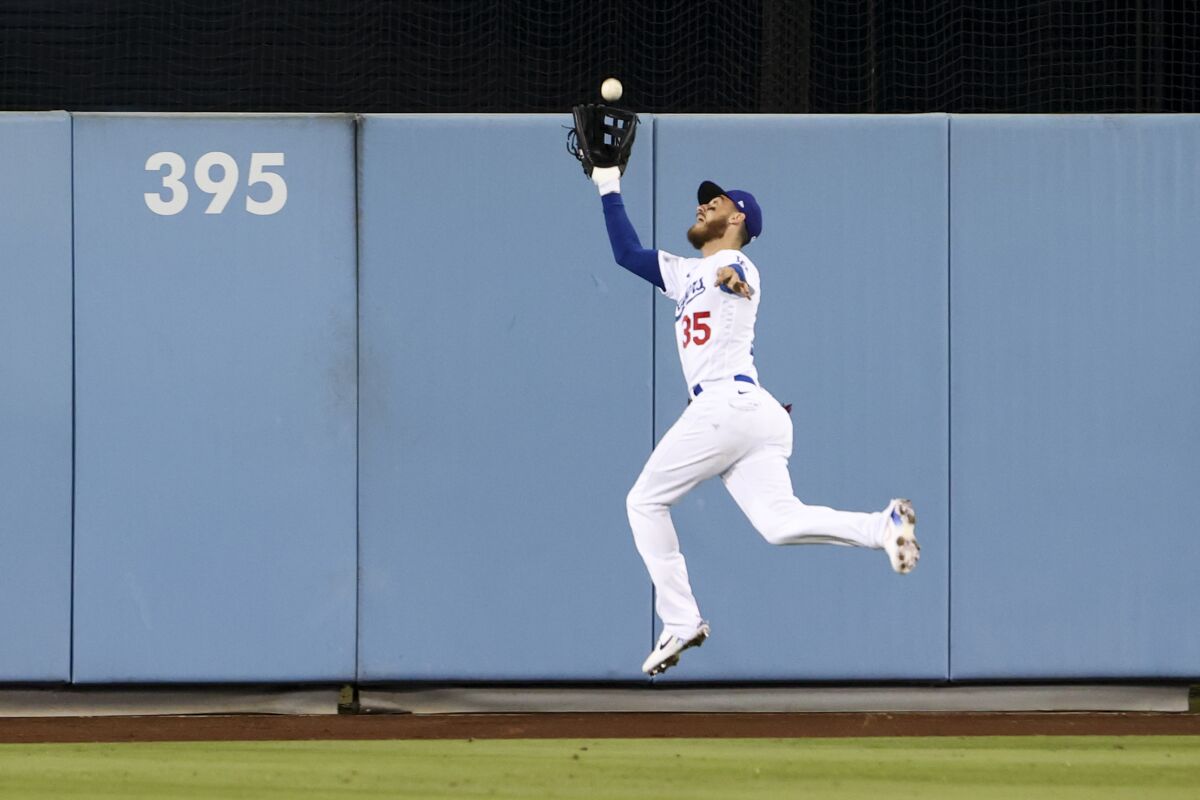 Dodgers center fielder Cody Bellinger catches a flyball hit by San Diego Padres' Austin Nola.