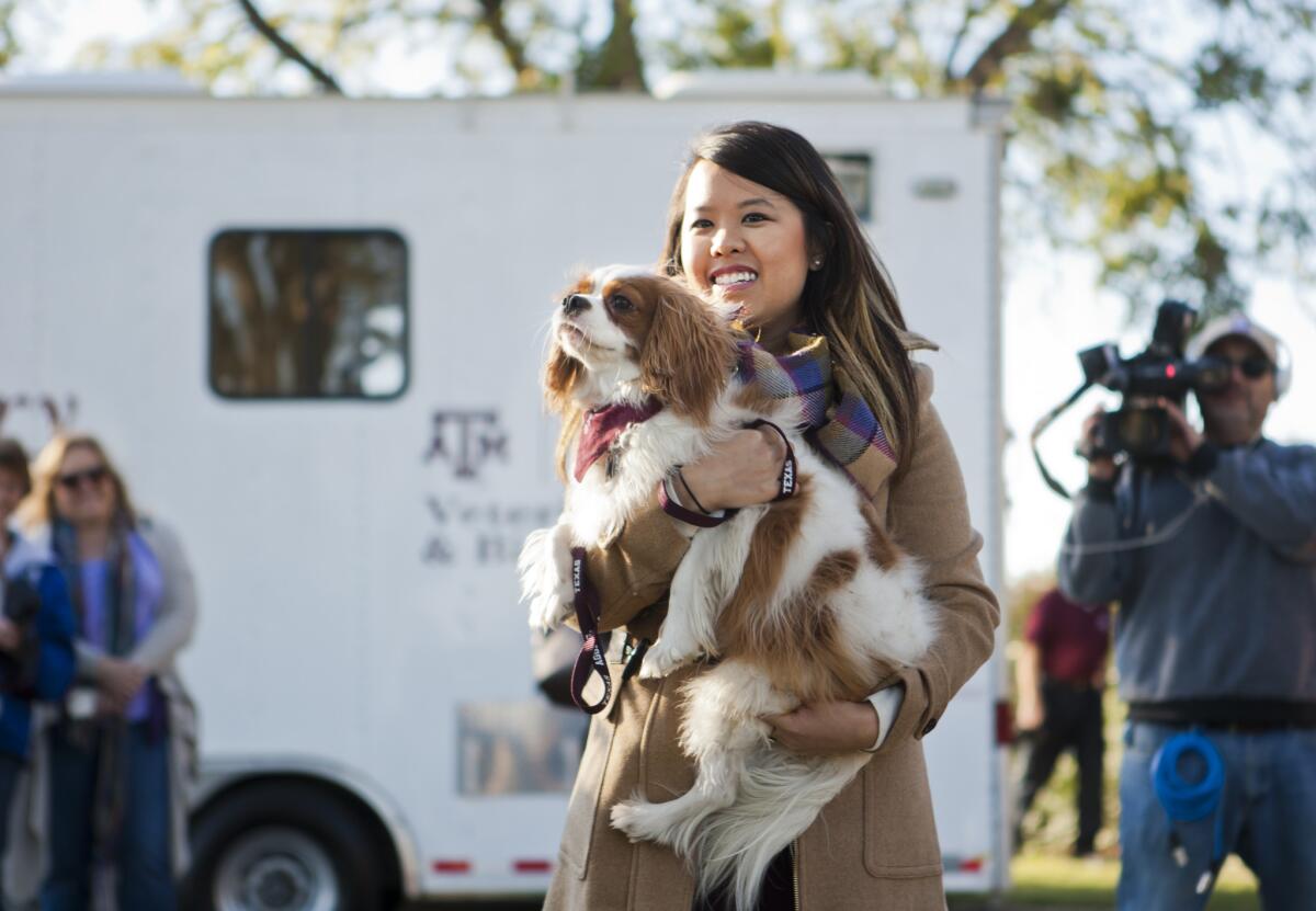 Nina Pham holds up Bentley, her King Charles spaniel, on Saturday at Hensley Field in Dallas.