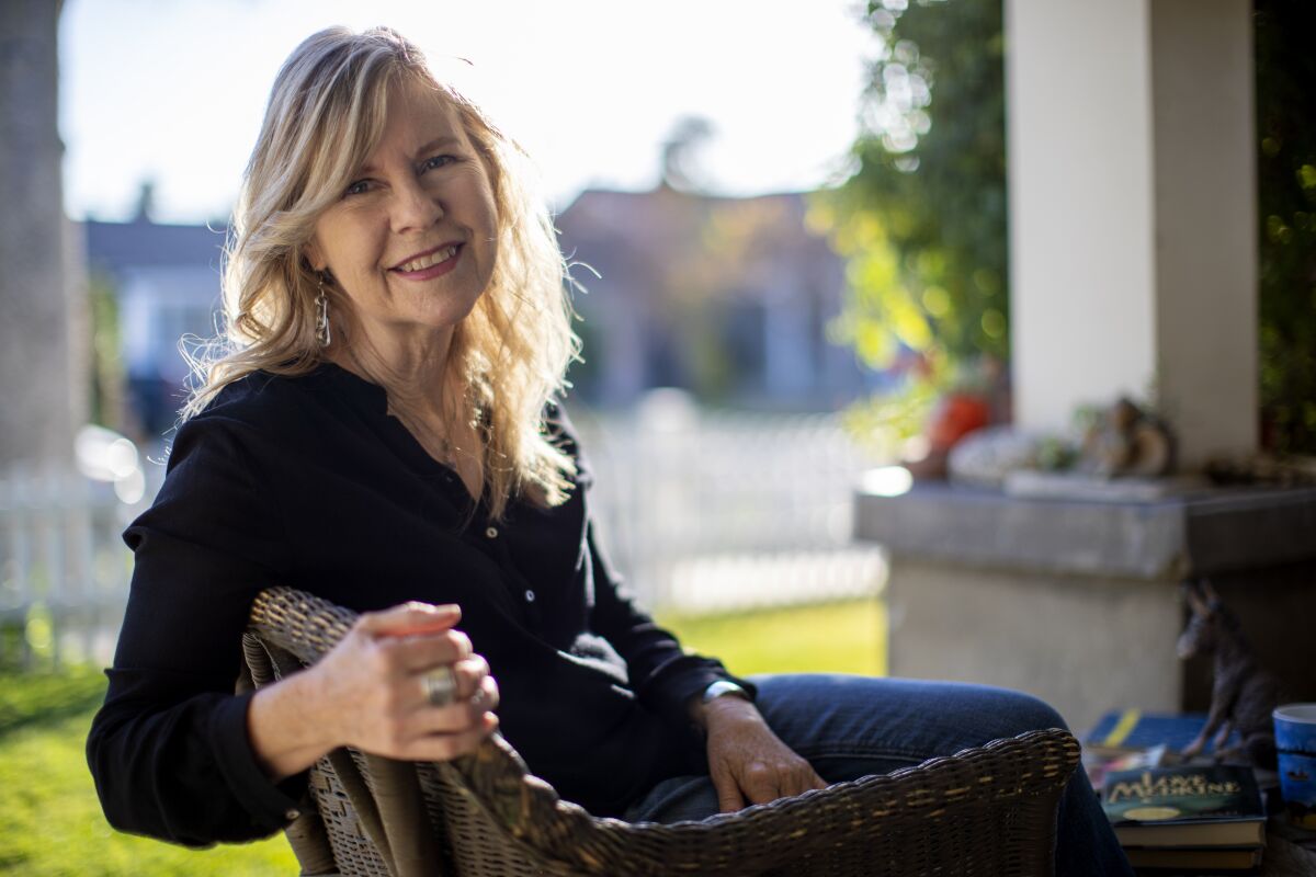 Susan Straight sits on her front porch in a favorite wicker chair in Riverside, California.