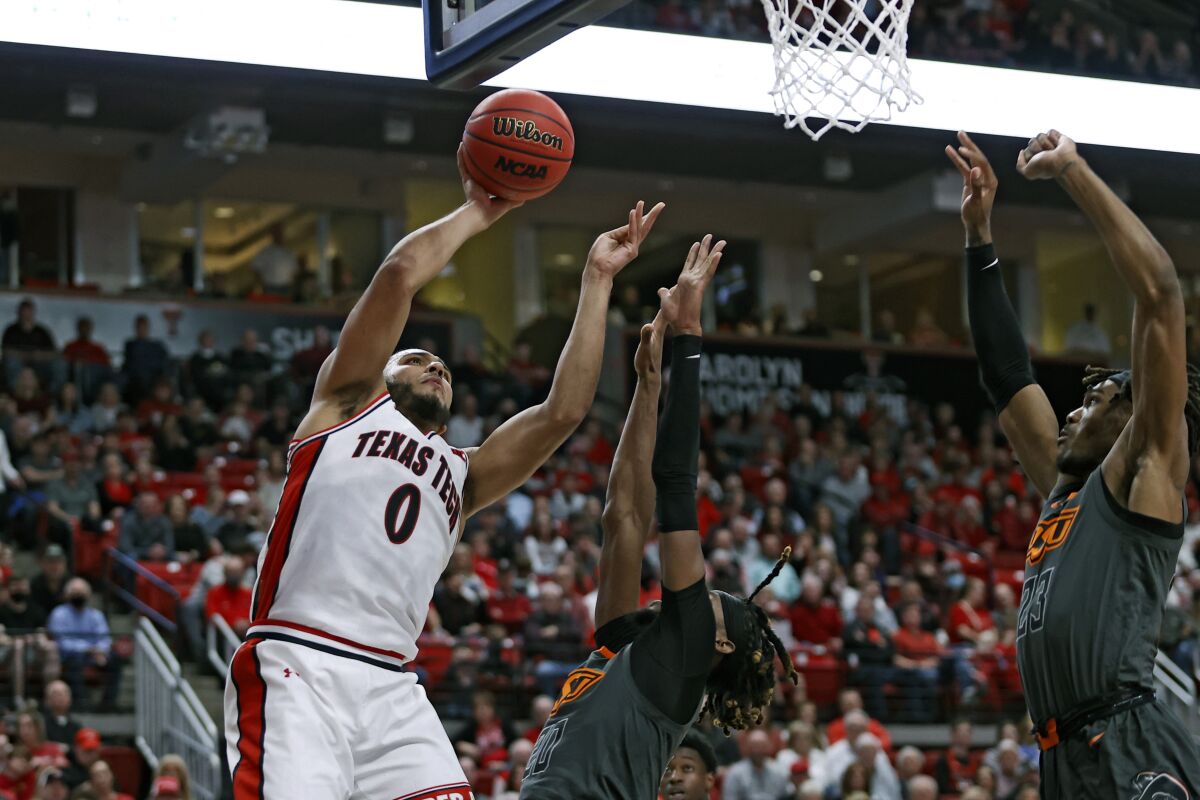 Texas Tech's Kevin Obanor (0) shoots the ball around Oklahoma State's Keylan Boone (20) during the first half of an NCAA college basketball game on Thursday, Jan. 13, 2022, in Lubbock, Texas. (AP Photo/Brad Tollefson)