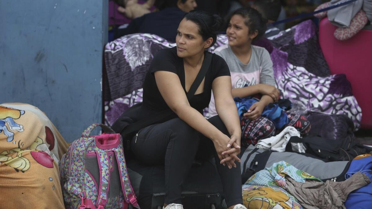 Venezuelan migrant Alejandra Zambrano, who said she's an unemployed journalist, waits for her turn to cross the border from Ecuador to Tumbes, Peru, on Saturday, June, 15, 2019.
