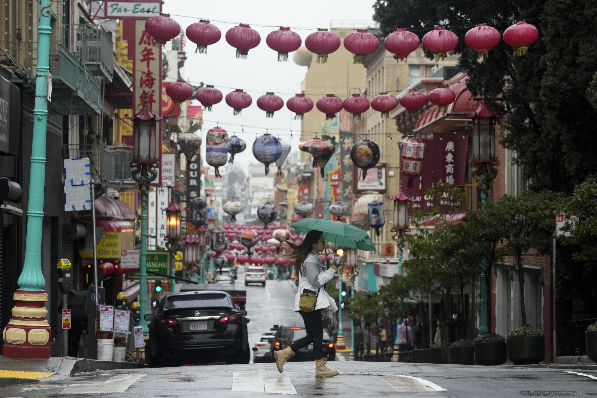 A woman crosses a street in Chinatown in San Francisco. 