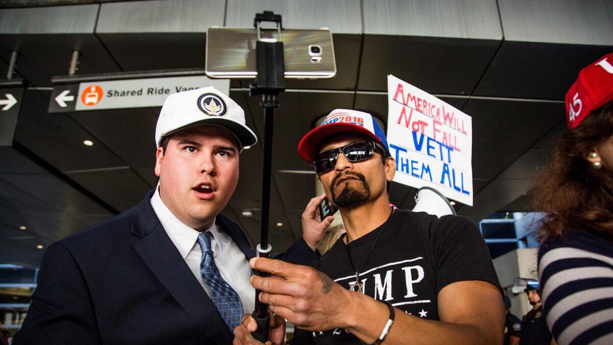Congressional candidate Omar Navarro, left, and Trump supporter Harim Uziel livestream their counterprotest after thousands showed up at Los Angeles International Airport in February to object to Trump's ban of immigrants from seven majority-Muslim countries.