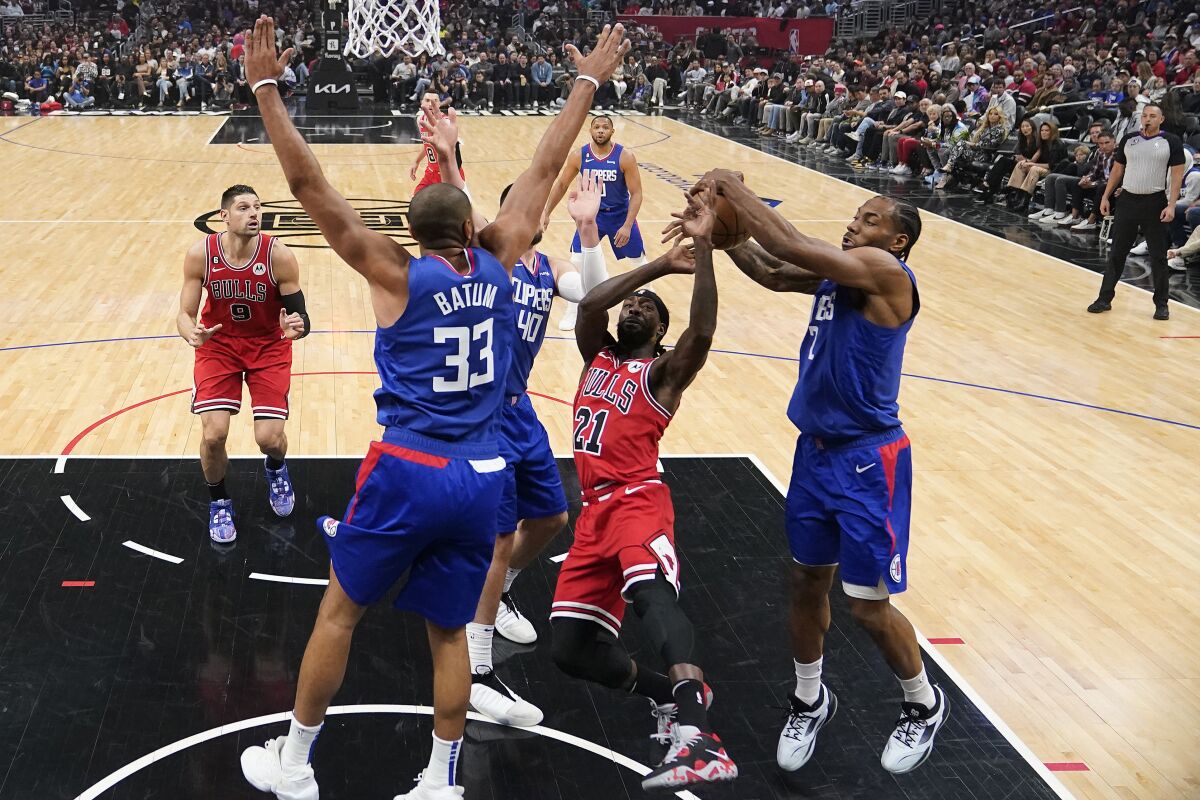 Los Angeles Clippers forward Kawhi Leonard, right, blocks a shot from Chicago Bulls guard Patrick Beverley (21) during the first half of an NBA basketball game Monday, March 27, 2023, in Los Angeles. (AP Photo/Marcio Jose Sanchez)