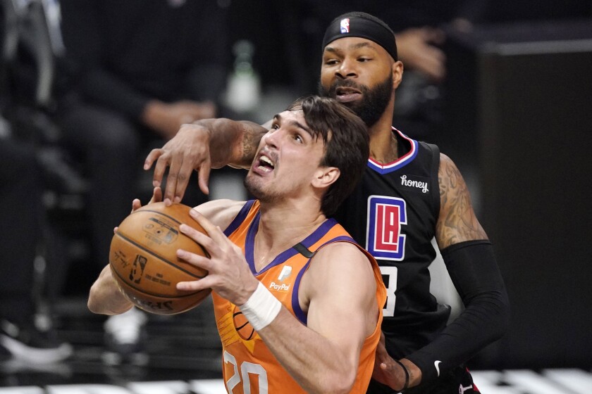 Phoenix Suns forward Dario Saric, left, shoots as Los Angeles Clippers forward Marcus Morris Sr. defends during the first half in Game 6 of the NBA basketball Western Conference Finals Wednesday, June 30, 2021, in Los Angeles. (AP Photo/Mark J. Terrill)