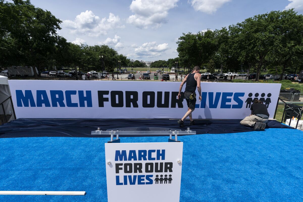 Workers set up for the March for Our Lives rally on the National Mall, near the White House, in Washington, Friday, June 10, 2022. The march is returning to Washington after four years. (AP Photo/Alex Brandon)