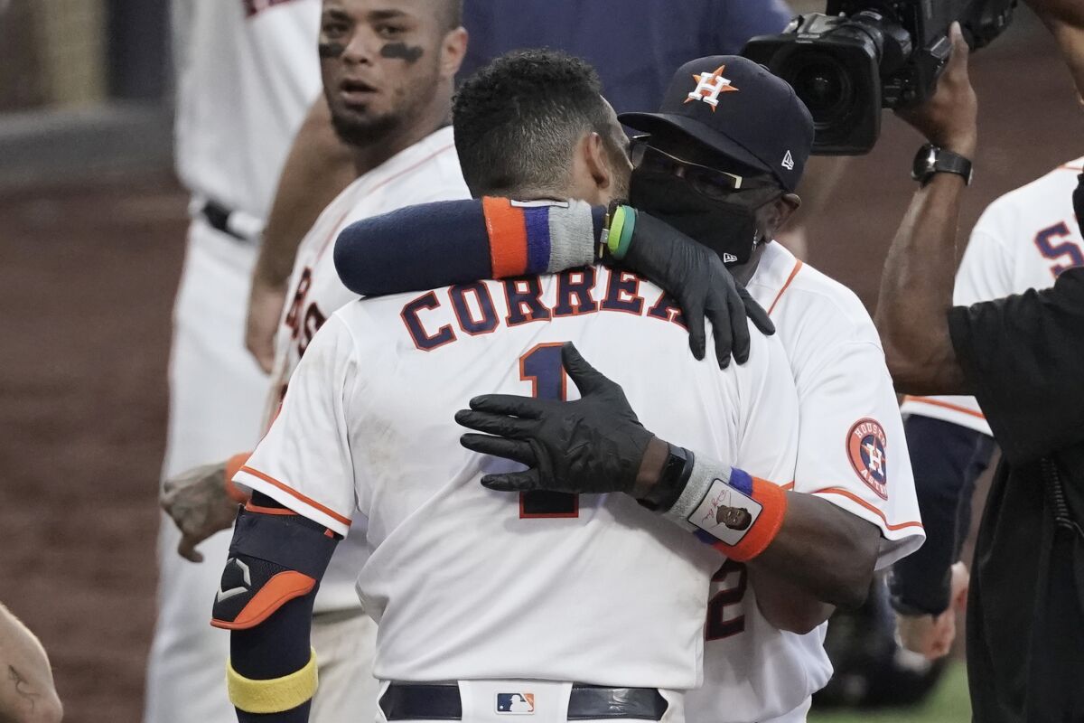 Houston Astros Carlos Correa is hugged by Houston Astros manager Dusty Baker Jr. after his walk off home run during the ninth inning in Game 5 of a baseball American League Championship Series, Tuesday, Dec. 15, 2020, in San Diego. The Astros defeated the Rays 4-3 and the Rays lead the series 3-2 games. (AP Photo/Ashley Landis)