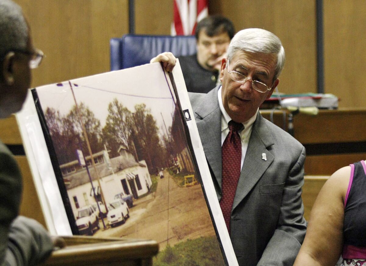 FILE - Prosecutor Doug Evans holds a photo during a trial for Curtis Flowers in court on June 14, 2010, in Greenwood, Miss. A federal appeals court on Thursday, June 16, 2022, affirmed the dismissal of a lawsuit that civil rights advocates filed against Evans. The 2019 lawsuit said Evans routinely rejected Black jurors in criminal cases because of their race, and it sought a declaration that Evans’ jury-selection practices violated prospective jurors’ constitutional rights. The appeals court ruled the plaintiffs lacked legal standing because they didn’t show an “immediate threat” that Evans could strike them from jury service. (Taylor Kuykendall/The Commonwealth via AP, File)