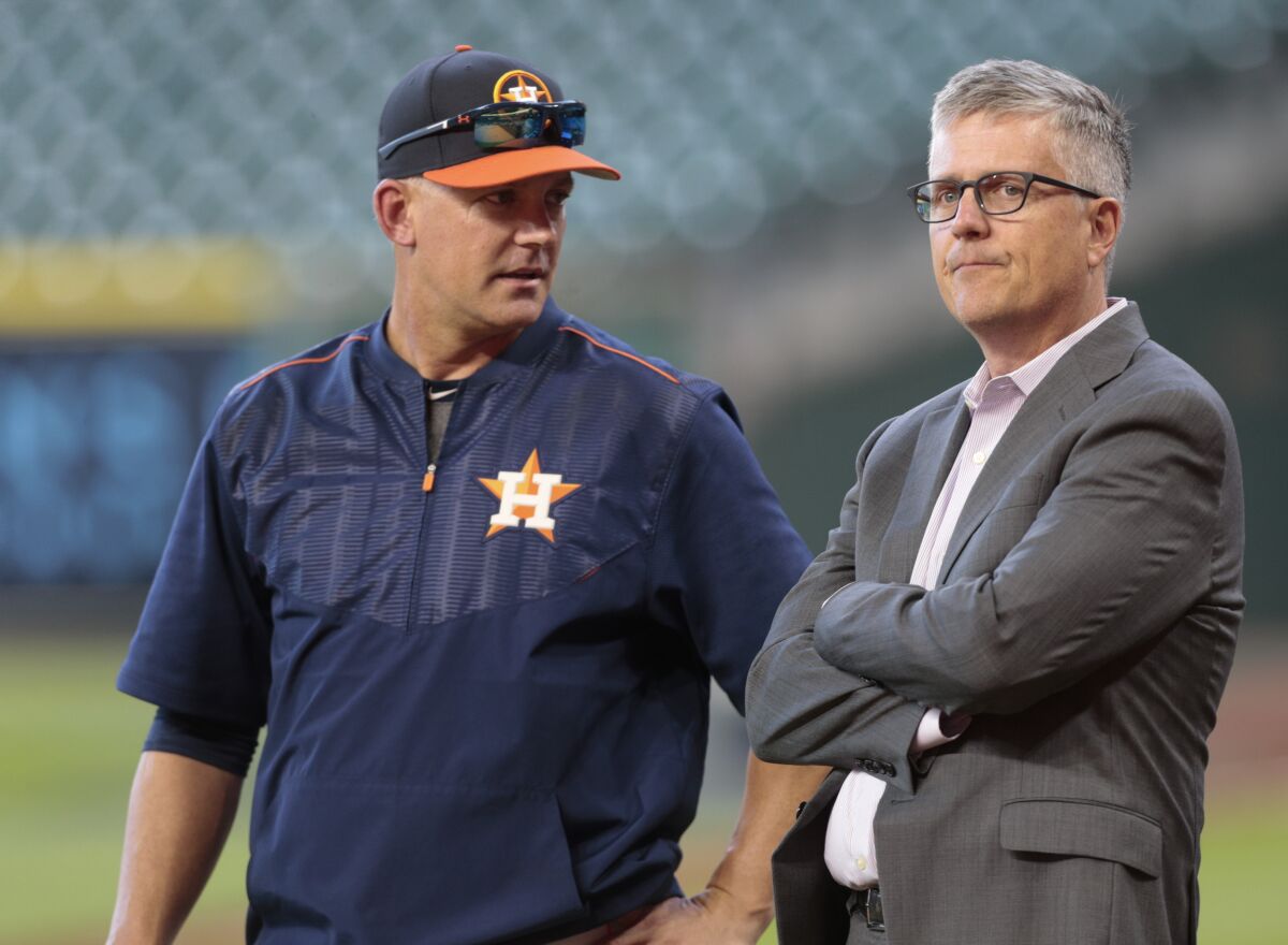 A.J. Hinch, left, and Jeff Luhnow talk during batting practice April 4, 2017, in Houston.