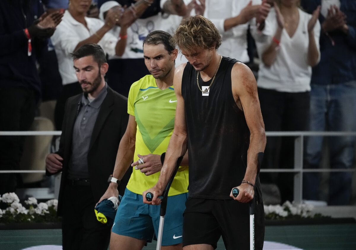 Spain's Rafael Nadal walks alongside Germany's Alexander Zverev who retired with an ankle injury in the semifinal match at the French Open tennis tournament in Roland Garros stadium in Paris, France, Friday, June 3, 2022. (AP Photo/Christophe Ena)