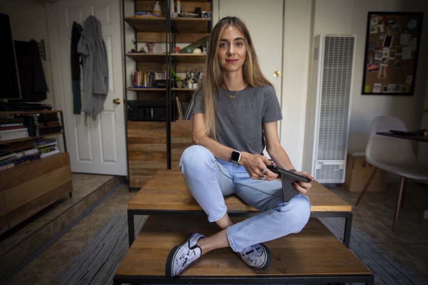 Keaton Kustler holds her Kindle in her L.A. apartment