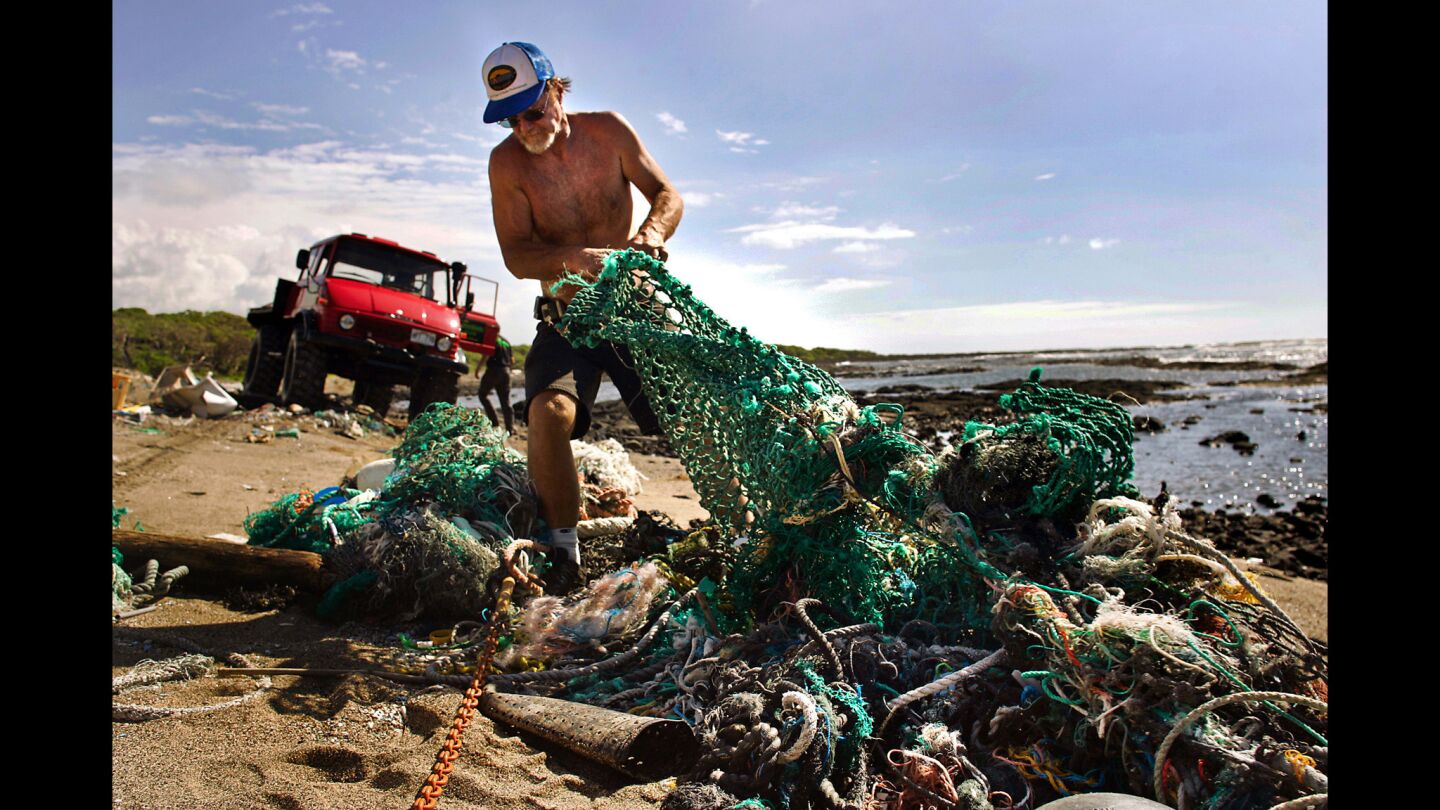 Volunteers haul trash off the otherwise pristine and uninhabited beaches on the coast of the Big Island in Hawaii. Tons of trash floating in the "garbage patch" between Hawaii and the mainland spins off onto Hawaiian beaches. Ghost netting, shown, frequently entangles marine mammals and causes their deaths.