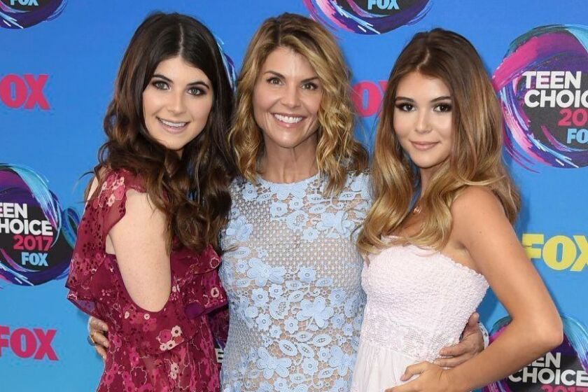 FILE - In this Aug. 13, 2017 file photo, actress Lori Loughlin, center, poses with her daughters Bella, left, and Olivia Jade at the Teen Choice Awards in Los Angeles. The FBI says actress Lori Loughlin has been taken into custody in connection with a scheme in which wealthy parents paid bribes to get their children into top colleges. FBI spokeswoman Laura Eimiller said Loughlin was in custody Wednesday morning in Los Angeles. She is scheduled to appear in court there in the afternoon. (Photo by Jordan Strauss/Invision/AP, File)