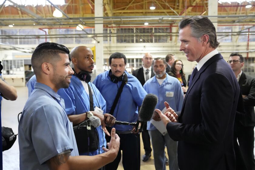 Incarcerated men visit with California Gov. Gavin Newsom after he spoke inside an empty warehouse at San Quentin State Prison in San Quentin, Calif., Friday, March 17, 2023. Newsom plans to transform the prison, a facility in the San Francisco Bay Area known for maintaining the highest number of prisoners on death row in the country. Newsom said his goal is to turn the prison into a place where inmates can be rehabilitated and receive job training before returning to society. (AP Photo/Eric Risberg)