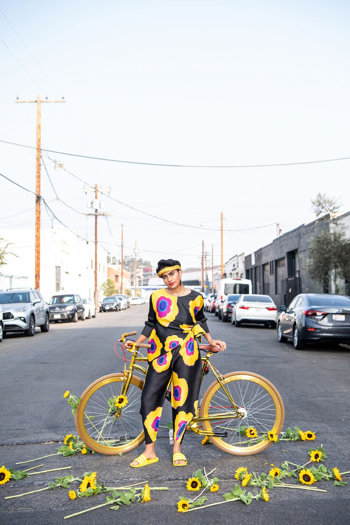 Portrait of Madame Gandhi with a bike and sunflowers around the Arts District.