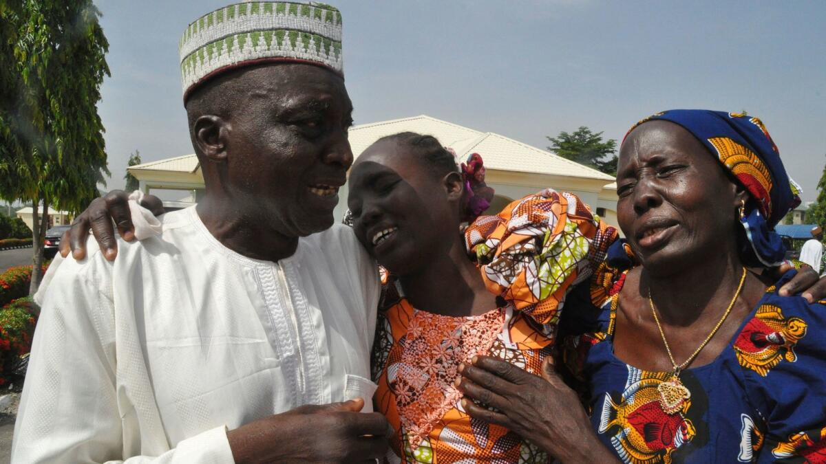 Family members celebrate as they embrace a relative, one of the released kidnapped schoolgirls, in Abuja, Nigeria, on Saturday.