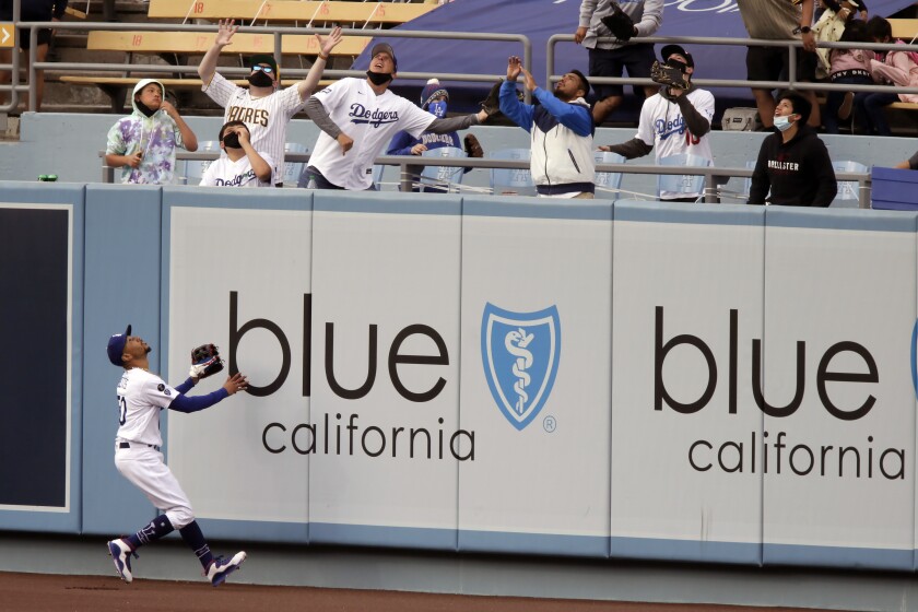Dodgers center fielder Mookie Betts watches as a ball hit by San Diego Padres’ Fernando Tatis Jr. clears the wall.