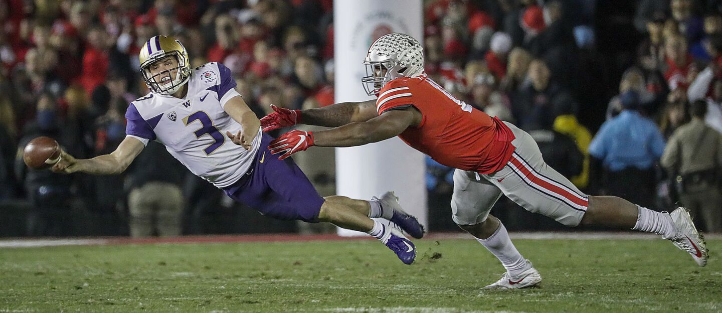 Washington quarterback Jake Browning throws a desparation pass as he scrambles away from Buckeyes defensive tackle Dre'Mont Jones in the 105th Rose Bowl Game at the Rose Bowl.