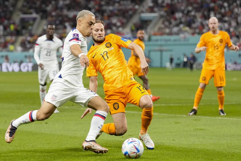 Sergino Dest of the United States, left, and Daley Blind of the Netherlands compete for the ball during the World Cup round of 16 soccer match between the Netherlands and the United States, at the Khalifa International Stadium in Doha, Qatar, Saturday, Dec. 3, 2022. (AP Photo/Ashley Landis)