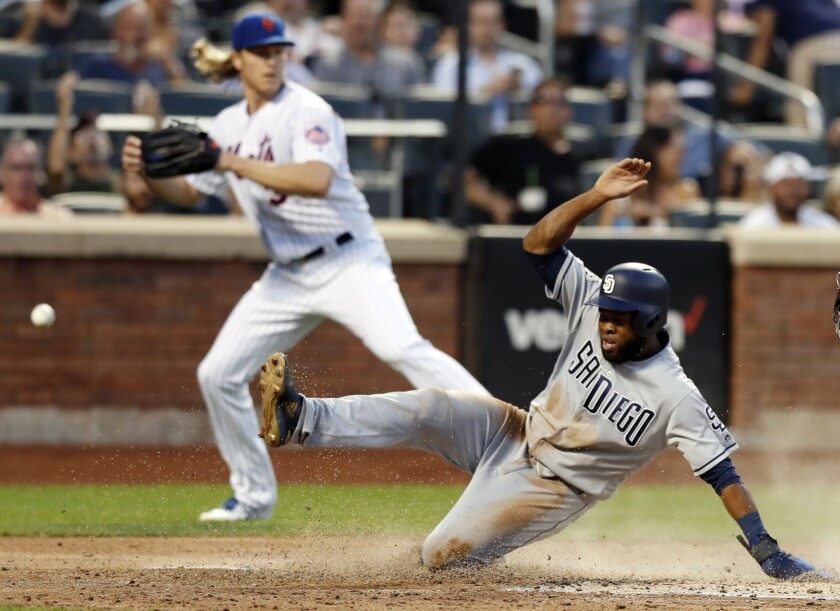 The Padres' Manuel Margot scores on Eric Hosmer's sacrifice fly in the third inning as Mets pitcher Noah Syndergaard backs up the play.