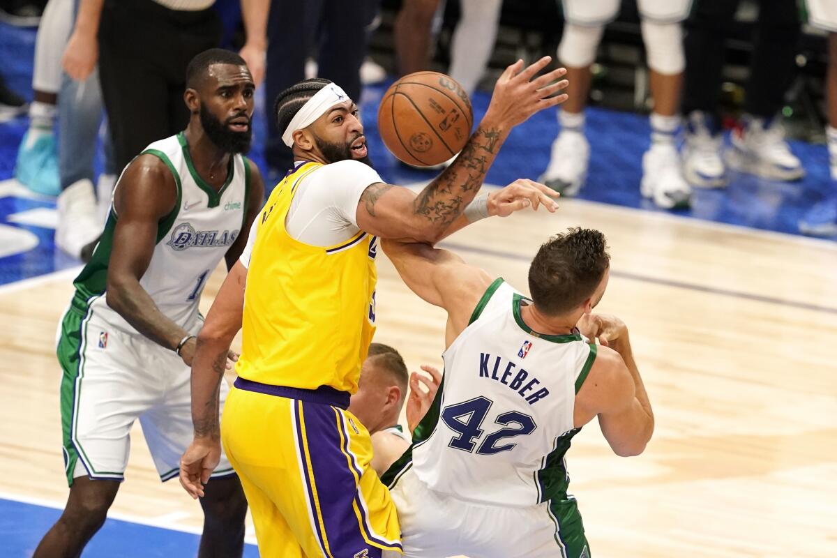 Dallas Mavericks teammates Tim Hardaway Jr., left, and Maxi Kleber battle Lakers forward Anthony Davis for a rebound.