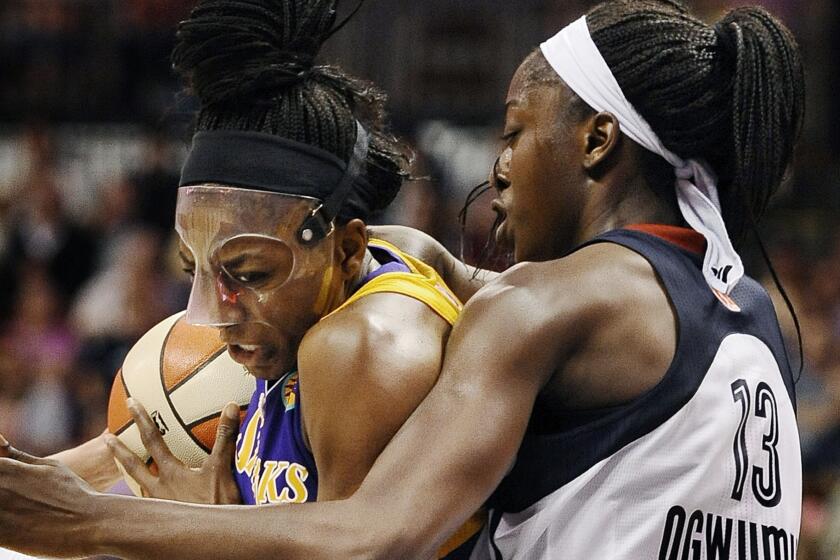 Sparks forward Nneka Ogwumike, left, drives to the basket while being guarded by her sister Chiney Ogwumike of the Connecticut Sun during the Sparks' 90-64 win Sunday.