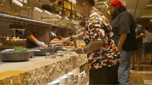 Animation of two men serving themselves food at a buffet.