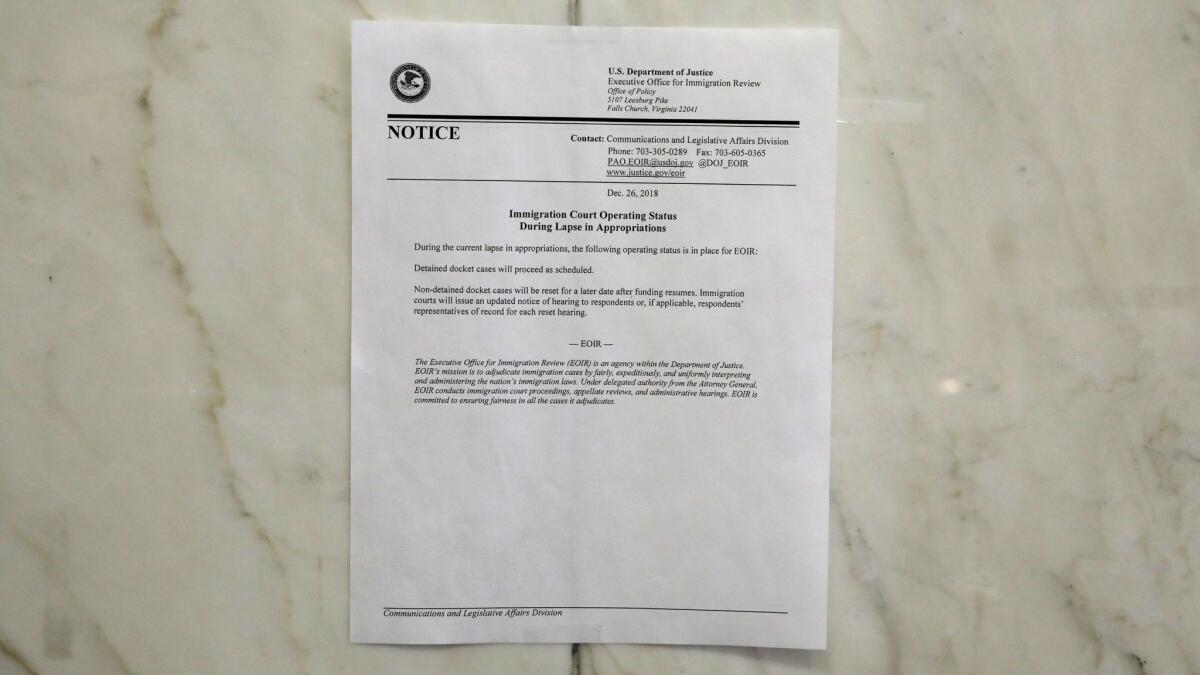 Dozens of immigrants have showed up at the Los Angeles Immigration Court every day. Many took photos of a notice taped near the elevators stating that cases would “be reset for a later date after funding resumes.”