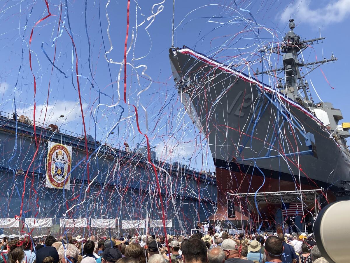 Streamers are shot in the air as a future U.S. Navy destroyer is christened.