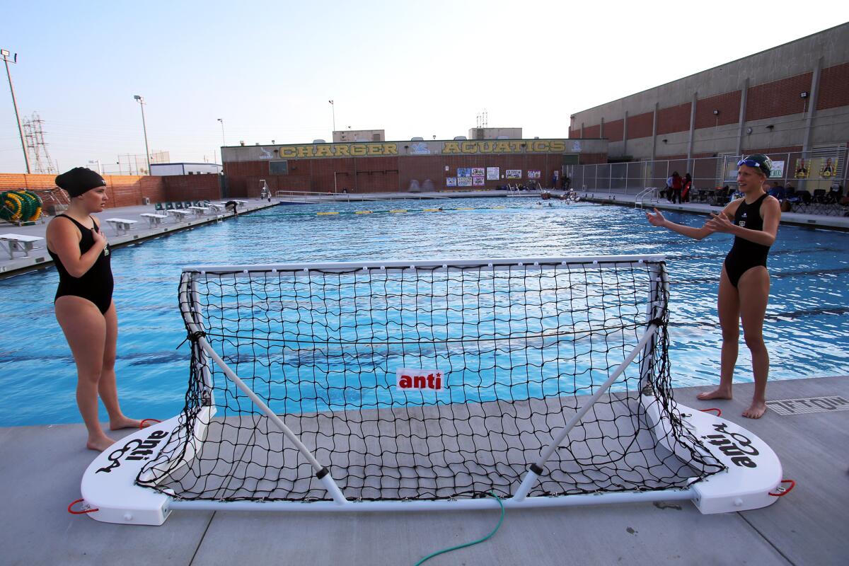 Edison High School's girls water polo team gets the net ready for before a home game against Fountain Valley.
