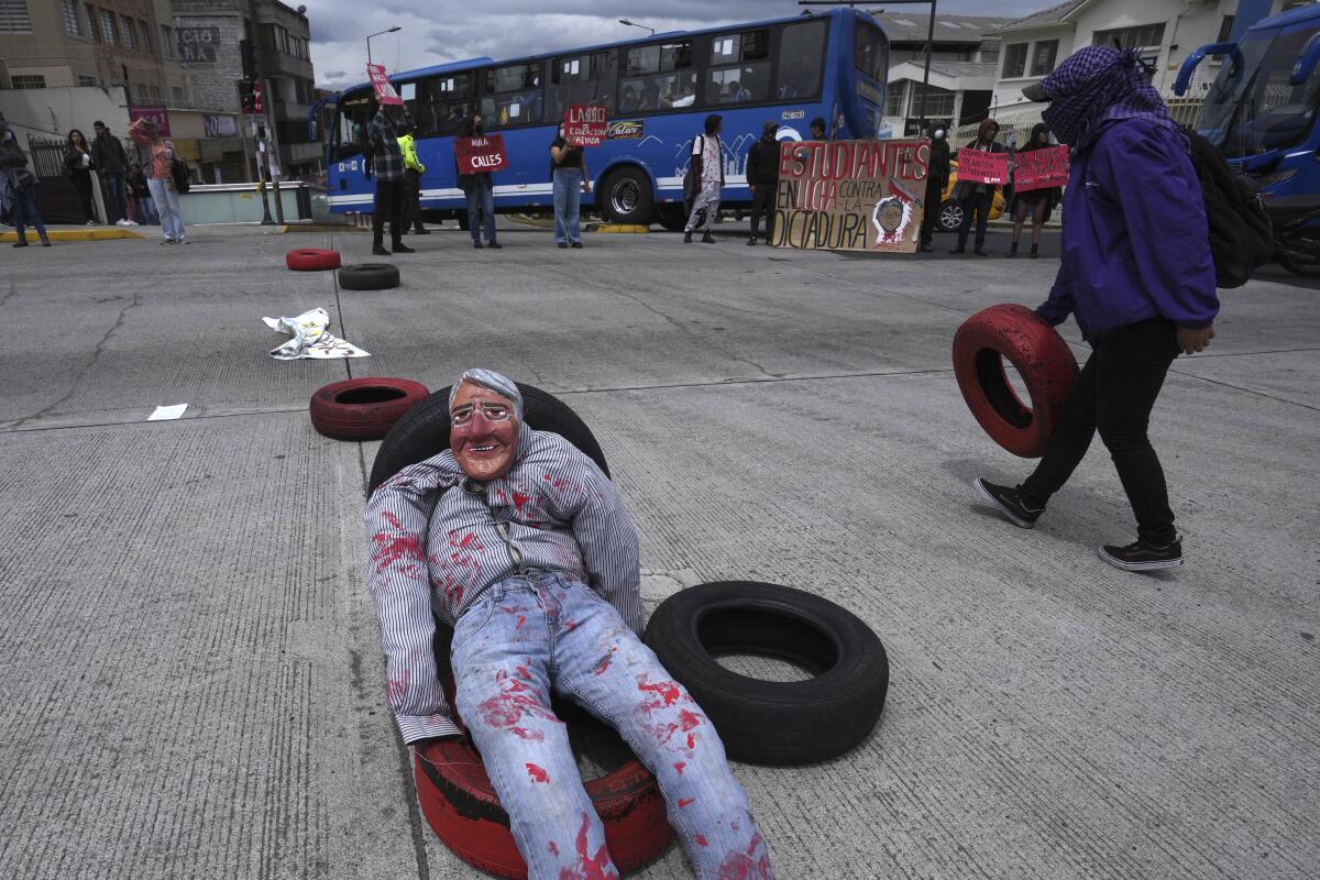 Un muñeco que representa al presidente de Ecuador, Guillermo Lasso, yace sobre neumáticos 