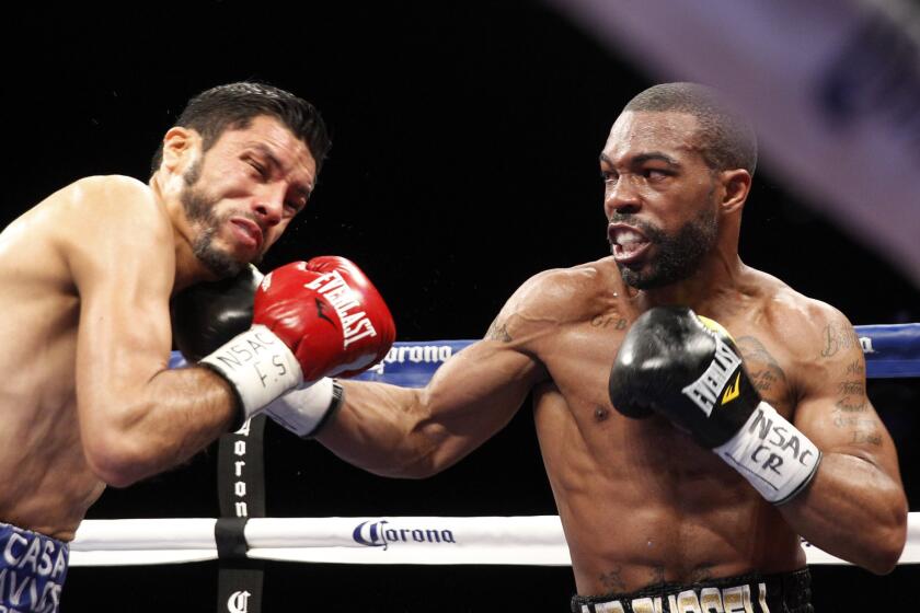 Gary Russell Jr.'s punch connects against WBC featherweight champion Jhonny Gonzalez, left, during their title fight in Las Vegas on March 28.