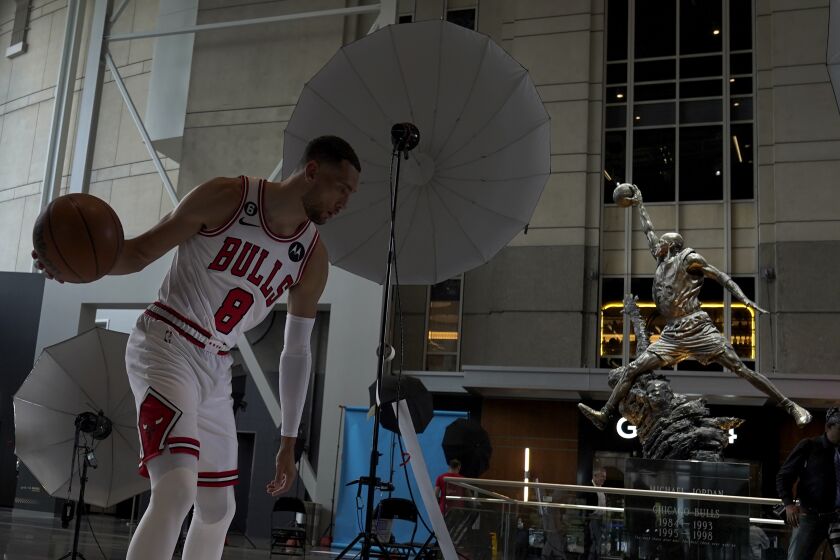 Chicago Bulls' Zach LaVine poses for a photograph near the Michael Jordan statue during the Bulls NBA basketball media day Monday, Sept. 26, 2022, in Chicago. (AP Photo/Charles Rex Arbogast)