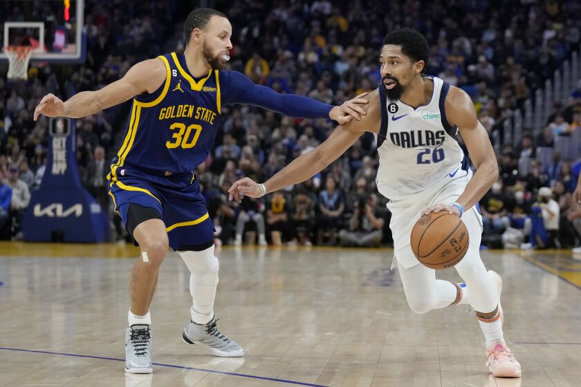 Dallas Mavericks guard Spencer Dinwiddie (26) drives to the basket against Golden State Warriors guard Stephen Curry (30) during the first half of an NBA basketball game in San Francisco, Saturday, Feb. 4, 2023. (AP Photo/Jeff Chiu)