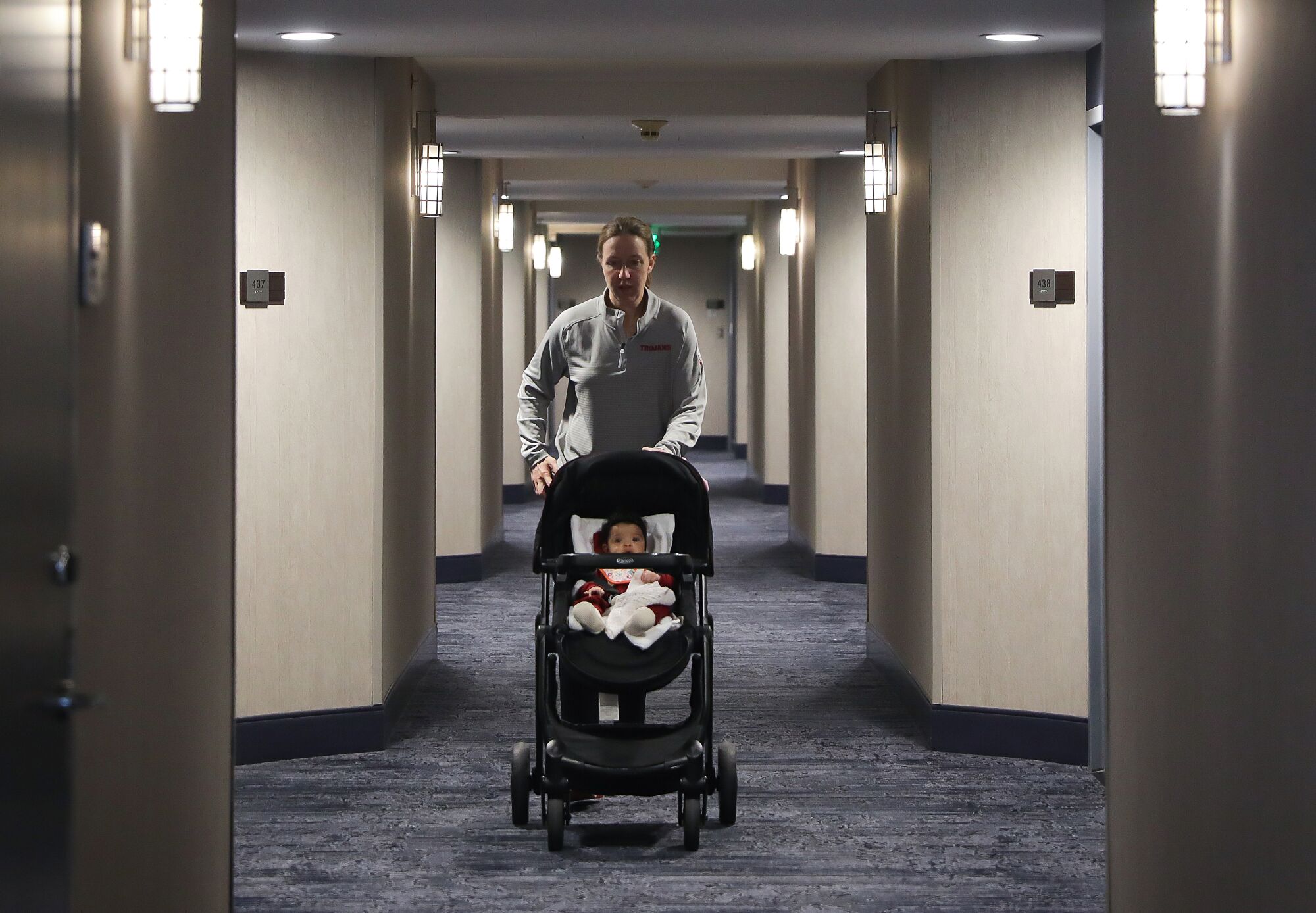 Lindsay Gottlieb pushes her daughter down the hallway at their hotel.